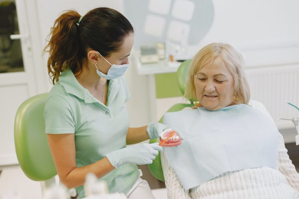 Dentist showing an elderly woman her denture