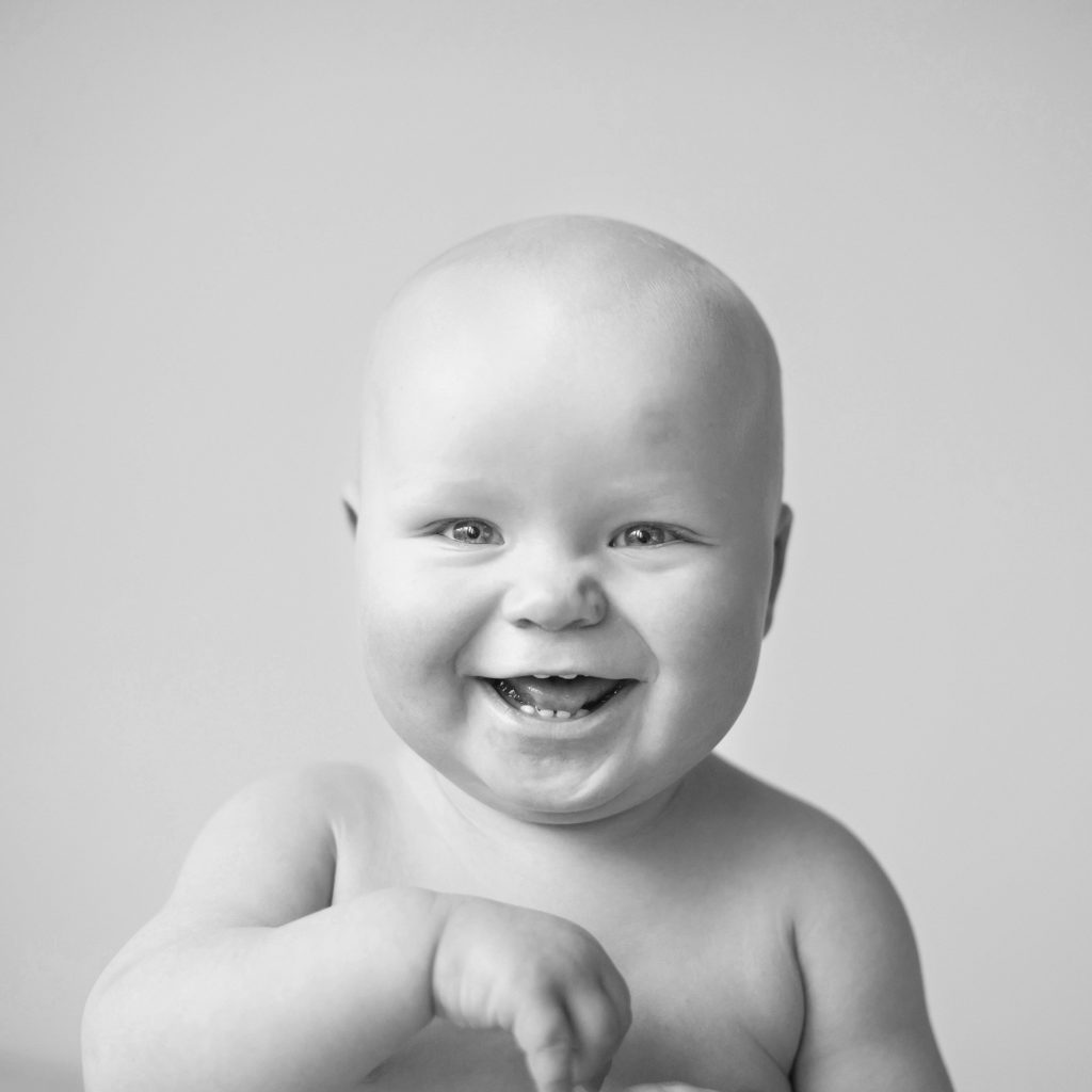 baby smiling with teeth in black and white