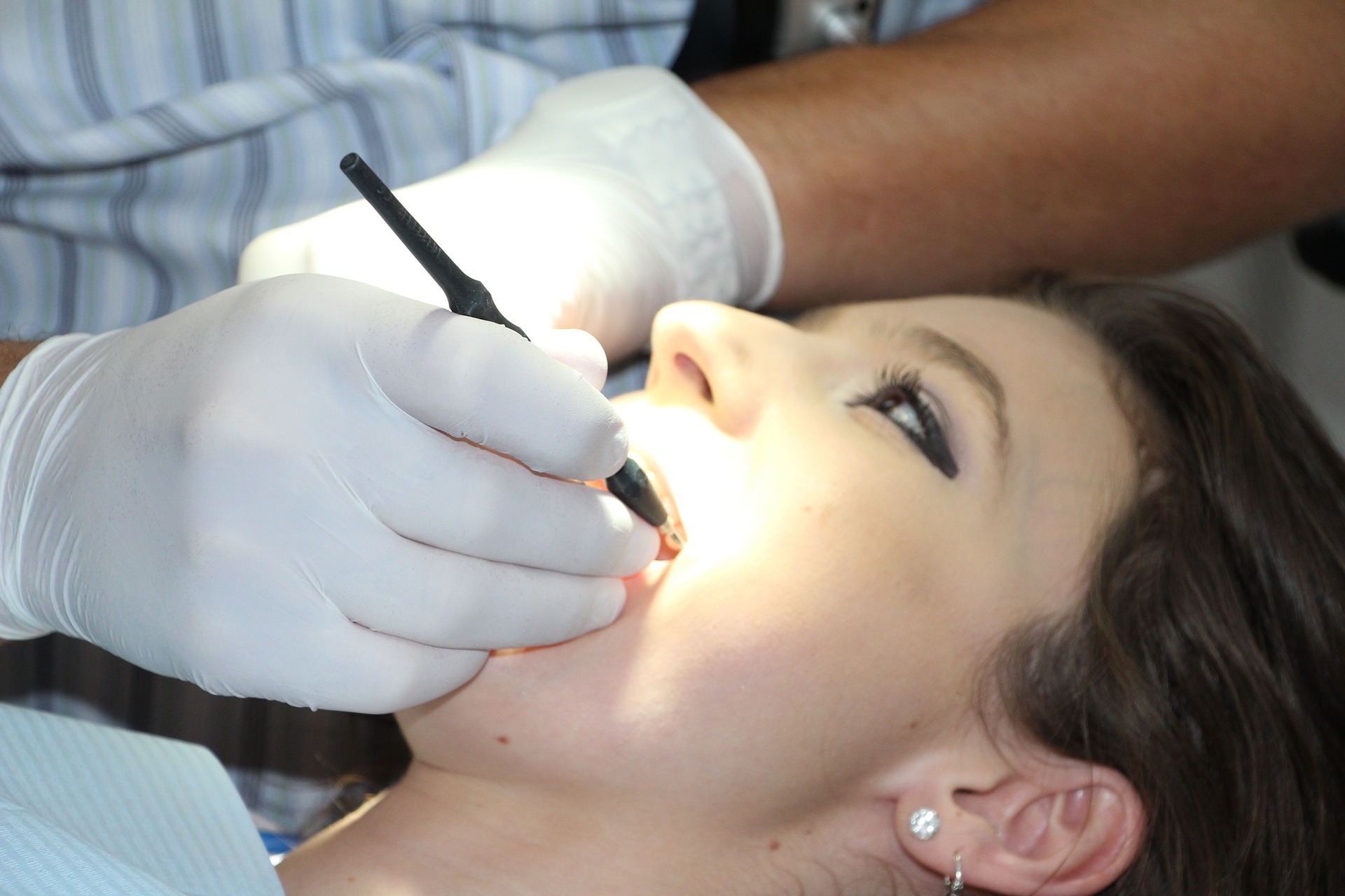 dental professional examining woman’s tooth