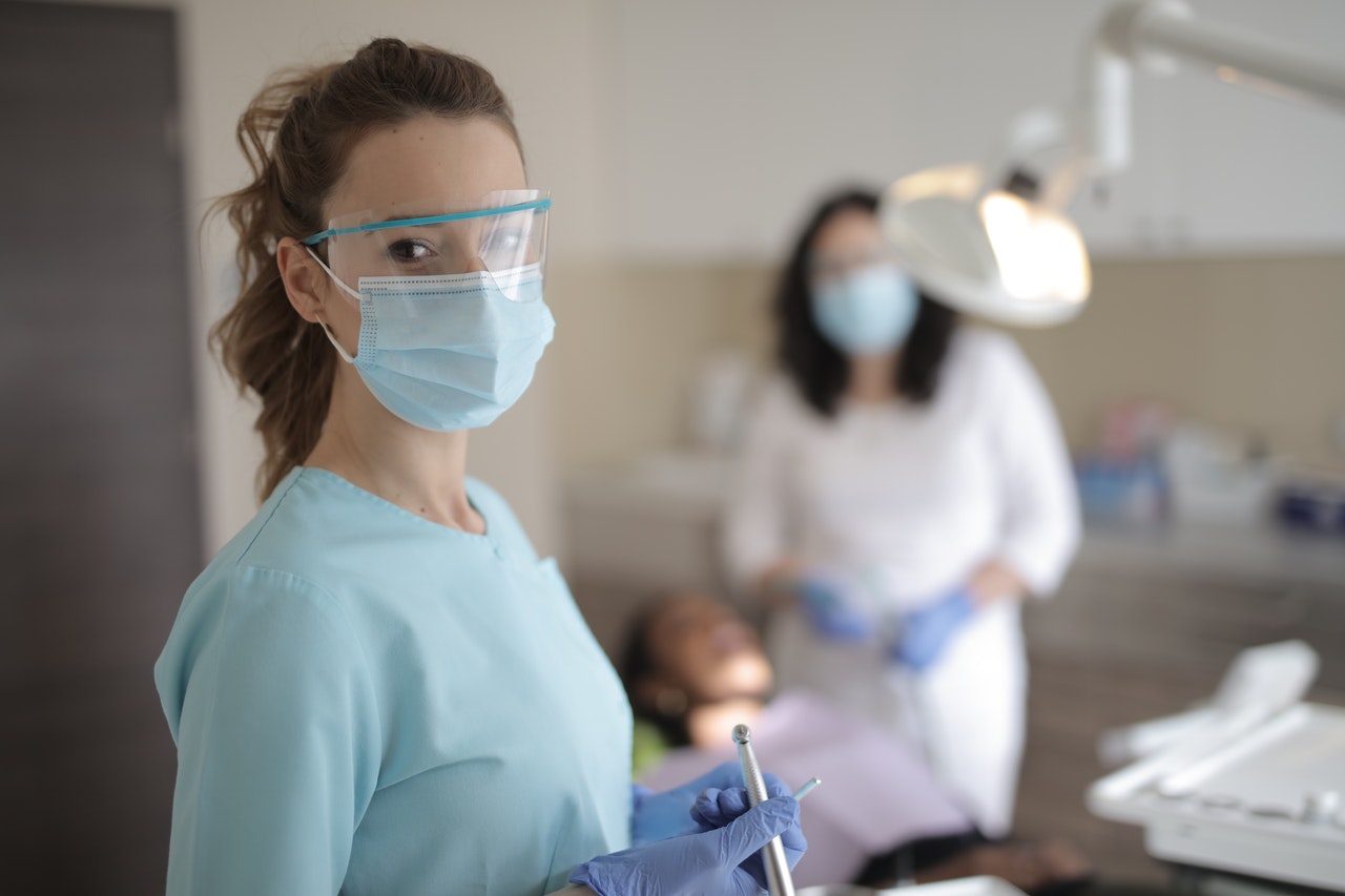 A dentist, technician, and patient prepare for a dental crown procedure