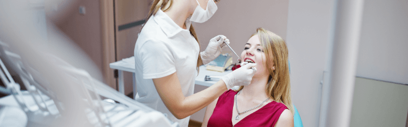 Dental Doctor Treating A Woman Smiling