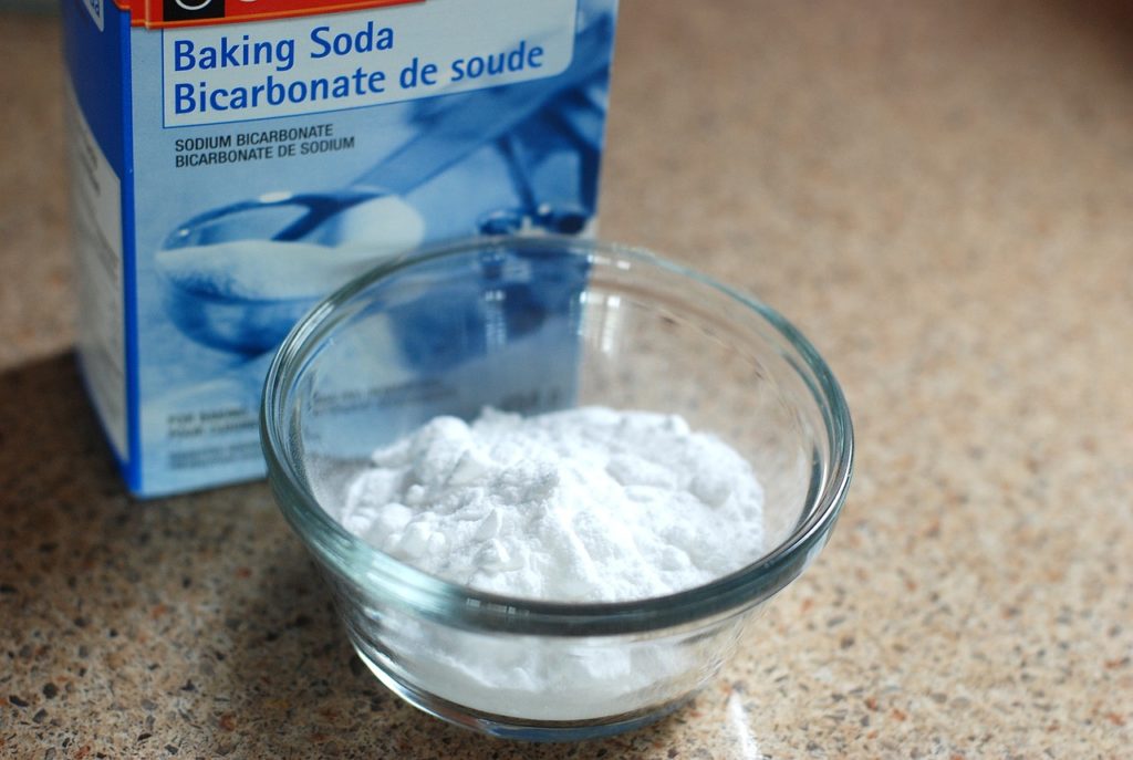 baking soda box near bowl containing baking soda