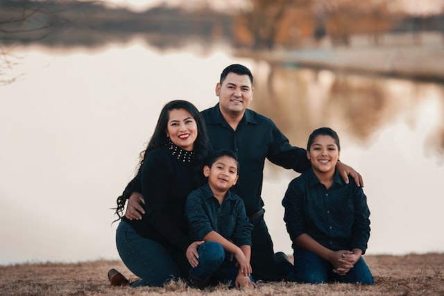 A smiling family beside a lake