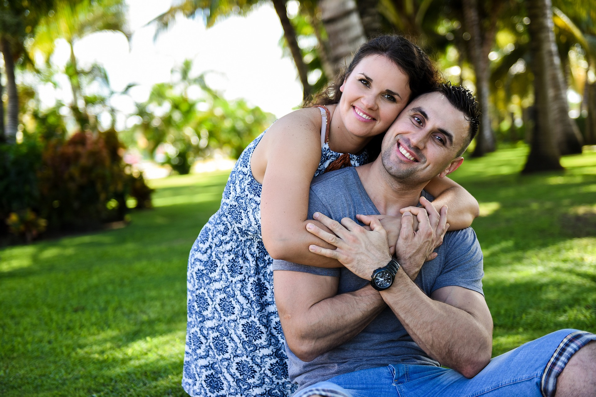 Woman and man holding each other and smiling with clean teeth