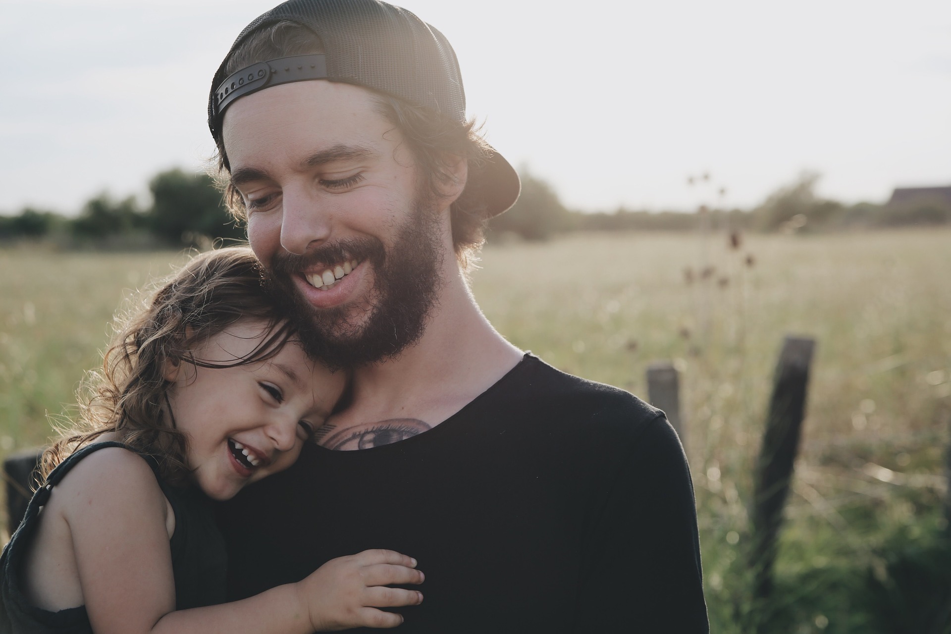 father holding daughter and smiling