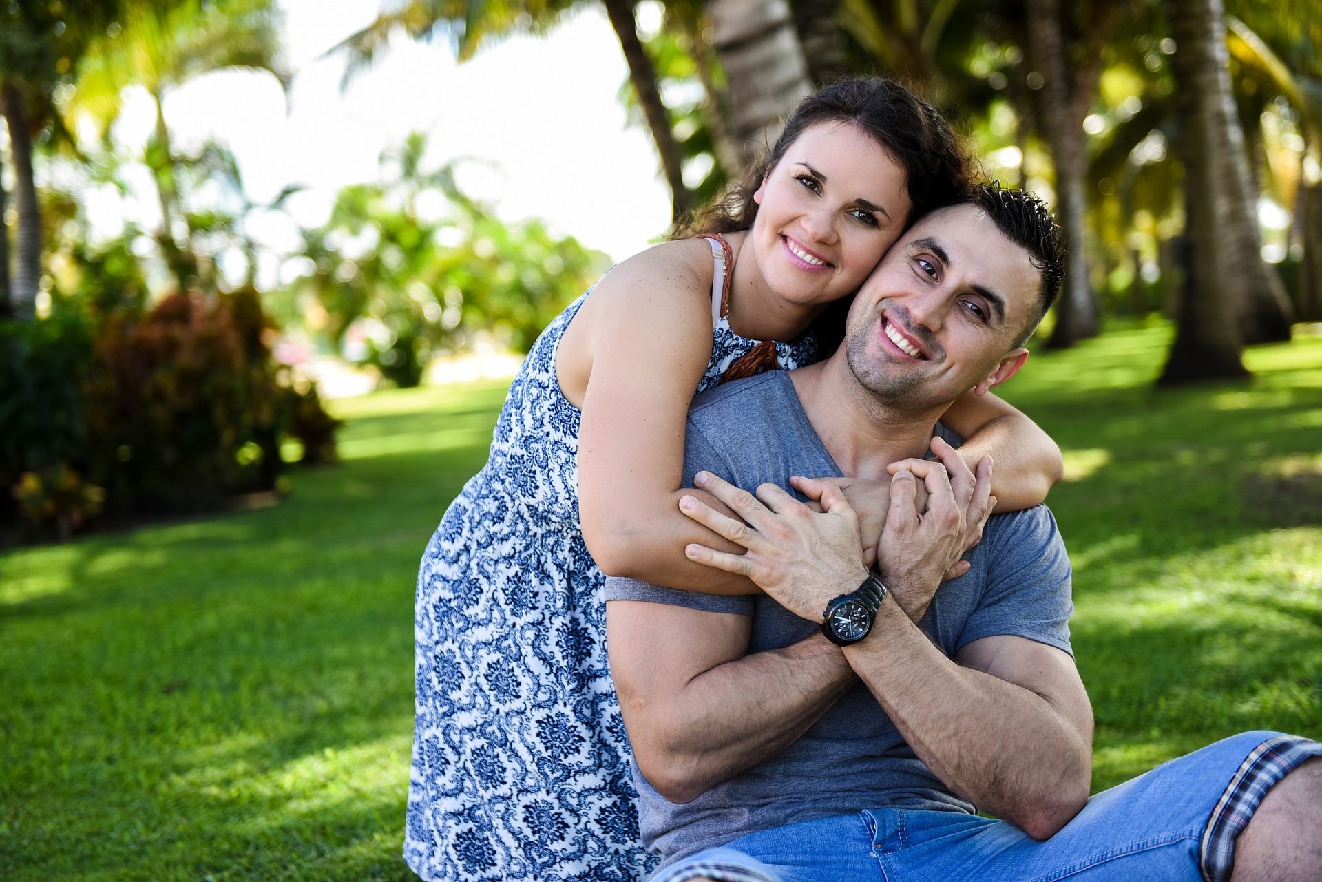 man and woman hugging and smiling on grass