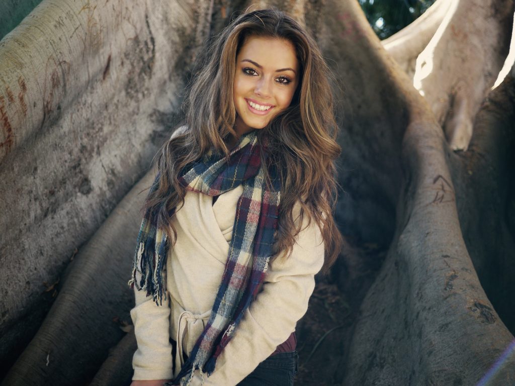 woman with a scarf smiling outdoors