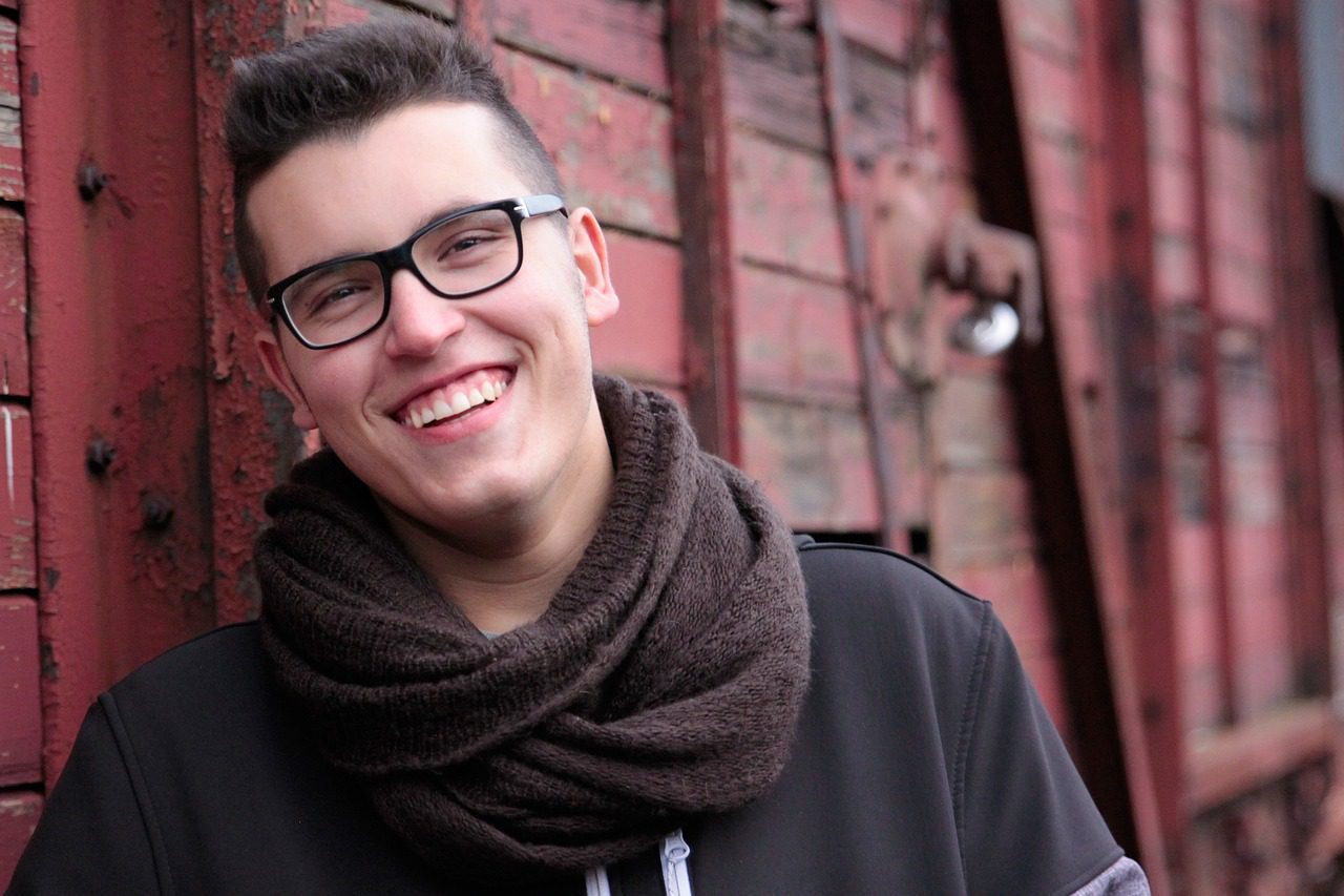 man smiling with scarf and glasses