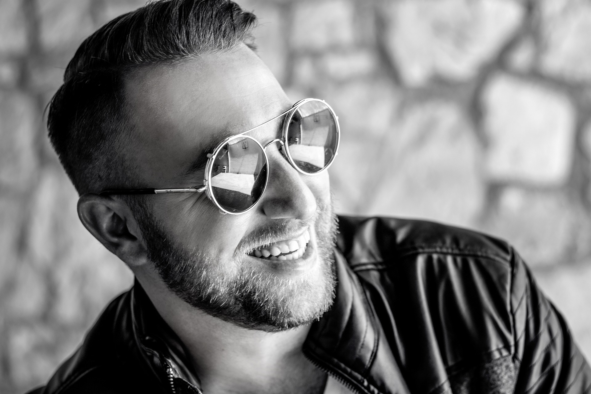 man smiling with sunglasses in black and white