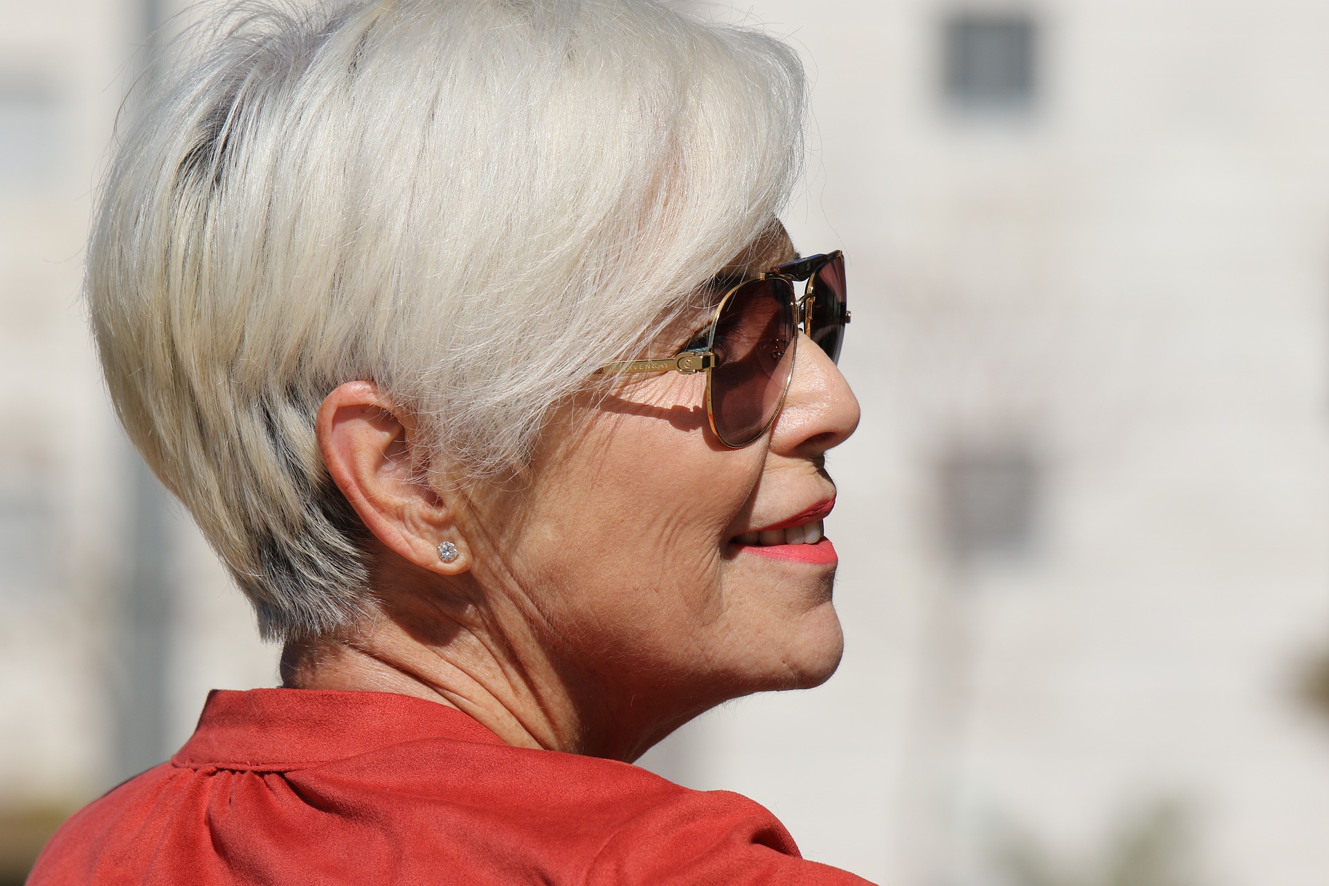 woman in orange smiling with sunglasses