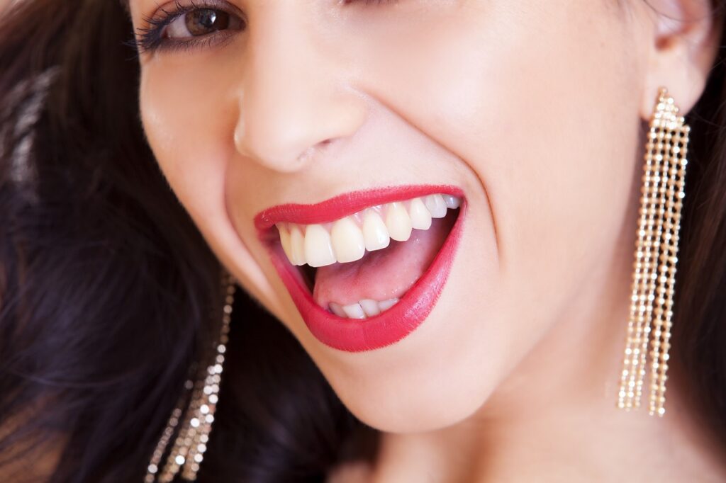woman smiling with lipstick and earrings