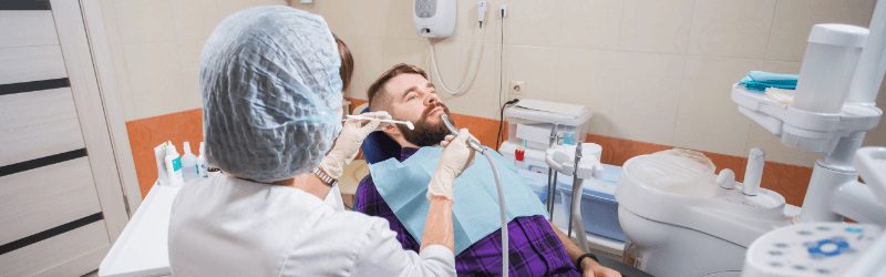 Dental hygienist preparing to clean teeth.