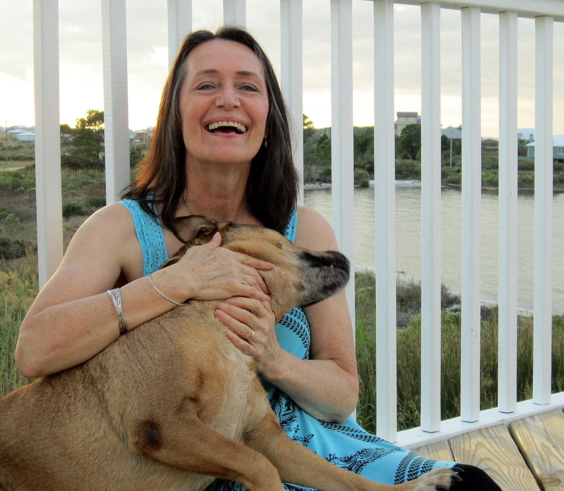 Woman wearing dentures smiling with a dog