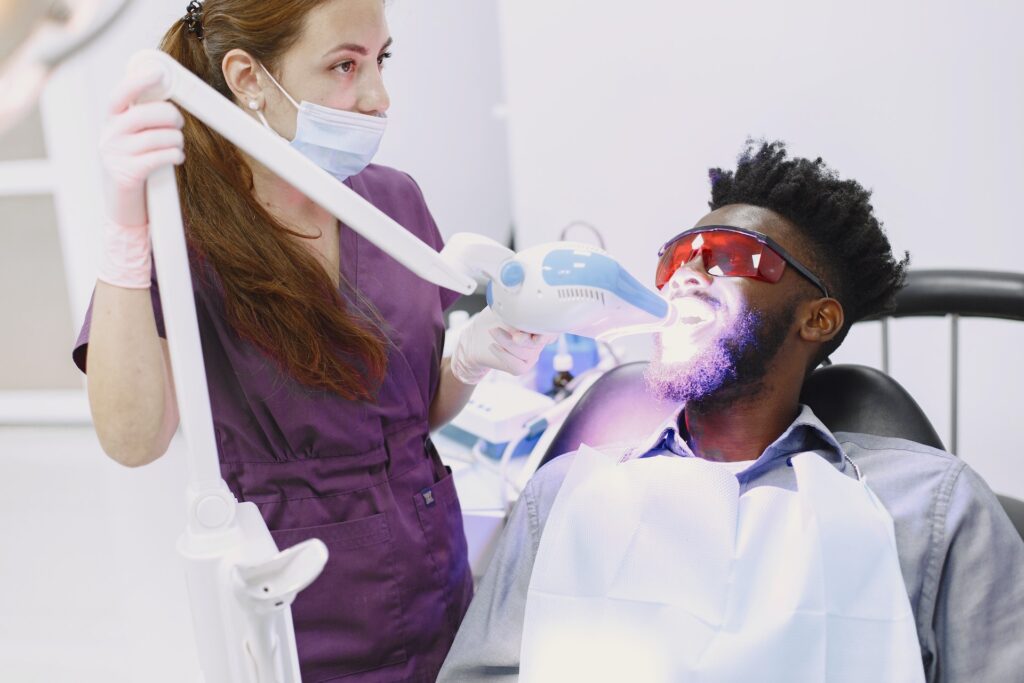 A man getting his teeth whitened by a dental hygienist 