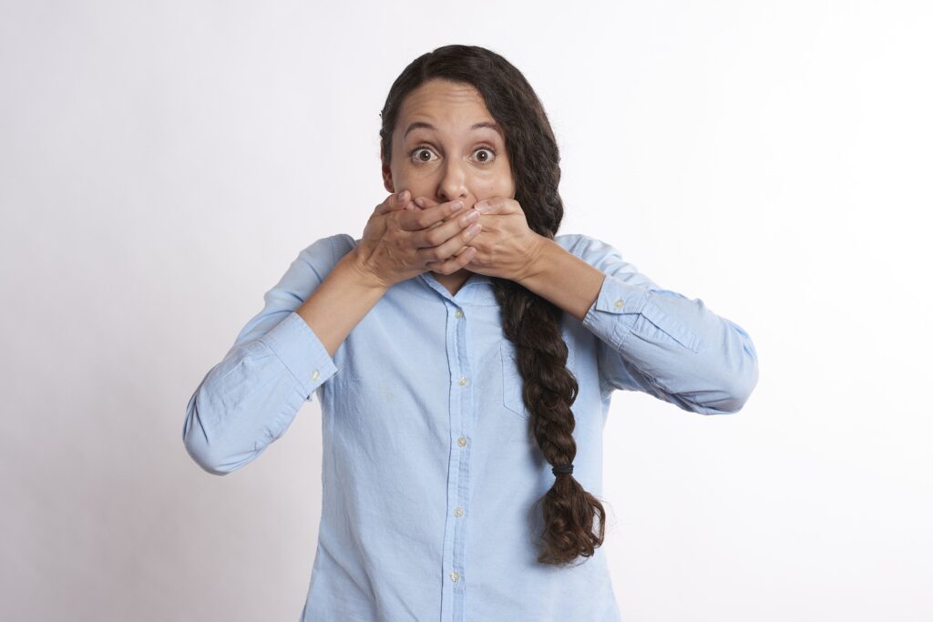 A woman covering her mouth with both hands