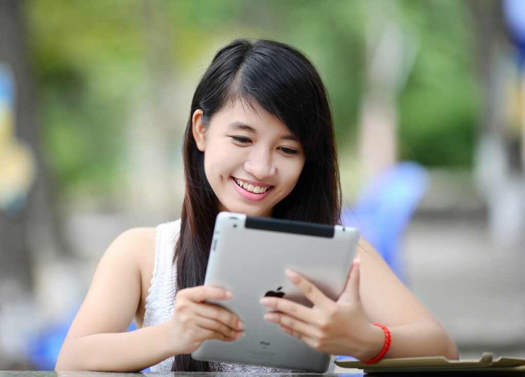 woman holding ipad with a smile