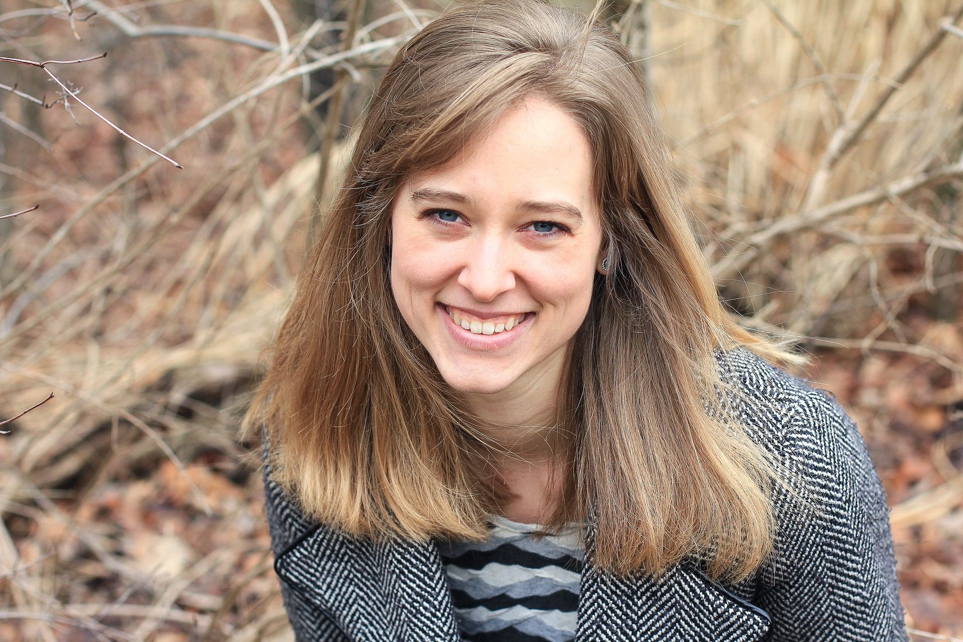 woman smiling outside with black and white jacket